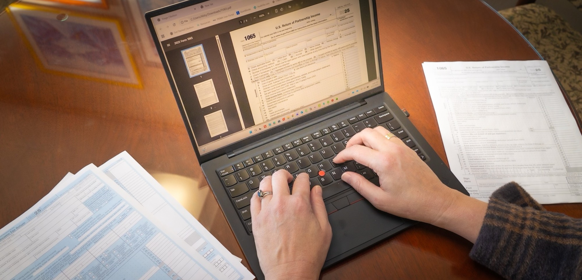 Person's hand working on taxes on a laptop